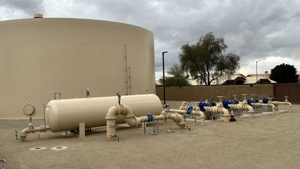 Pressure tanks and valve manifold at the base of a water storage tank