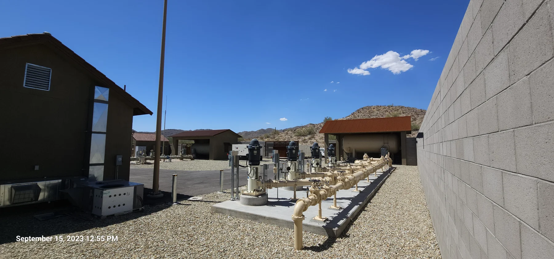 Water meter and valve assemblies at an EPCOR utility site with desert hills in the background