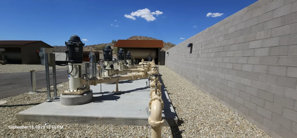 Water pump motors and valve piping on a concrete pad at a desert utility facility