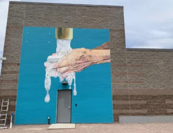 Exterior of 33rd Street Pump Station building featuring a large water-themed hand-washing mural on the facade