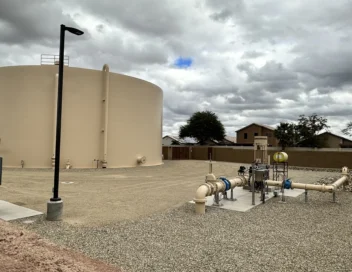 Water storage tank and pump station piping under cloudy skies