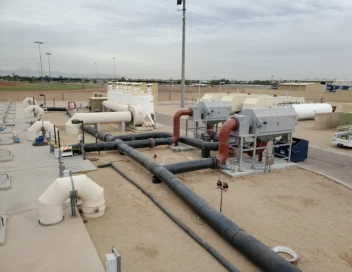 Elevated view of a water treatment facility with large-diameter piping and aeration equipment