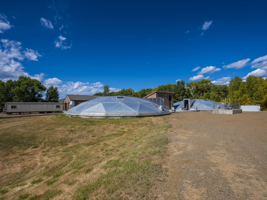 Completed RAS-WAS pumping station with aluminum dome covers surrounded by green landscape