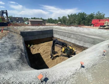 Active excavation site at Northglenn Lift Station A with excavator working in a large concrete-lined pit