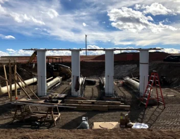 Structural columns and beam framing for well house modifications with dramatic cloud-filled sky