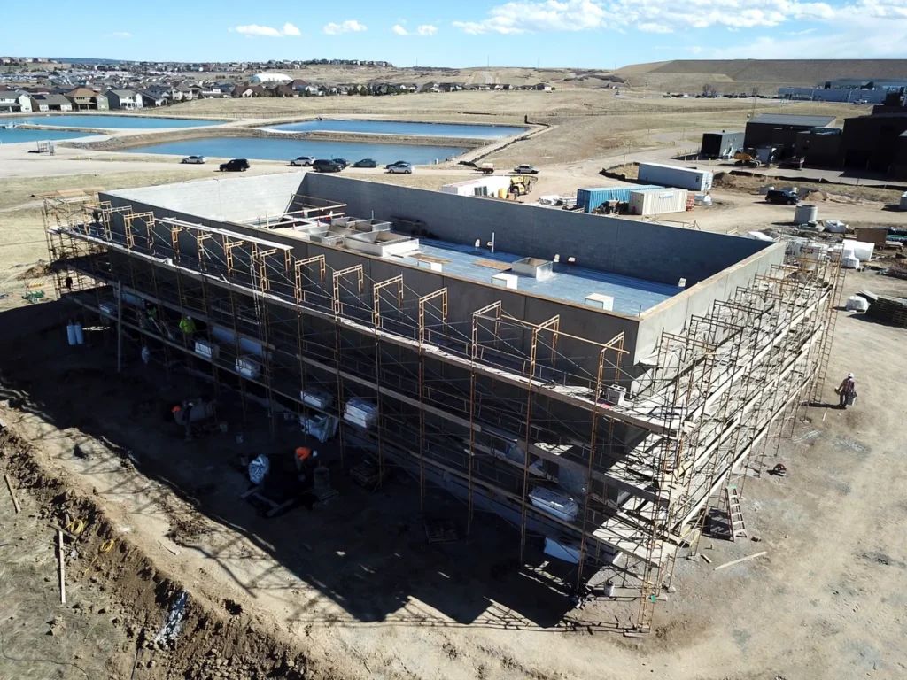 Aerial view of WISE Pump Station under construction with scaffolding and reservoir in background