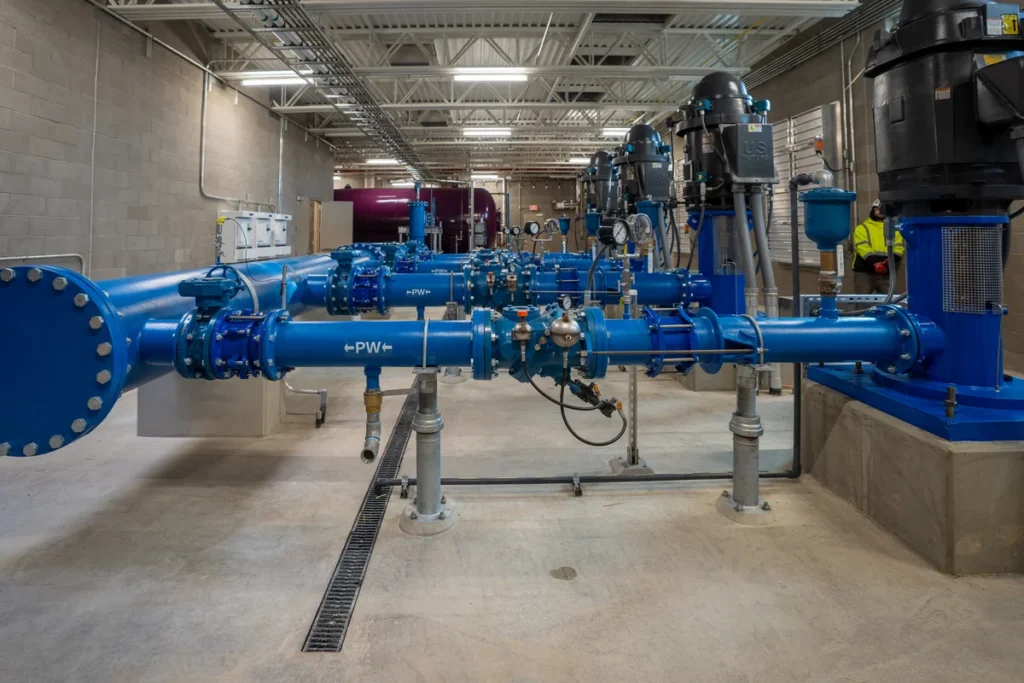 Interior of WISE Pump Station with blue potable water piping, valves, and pump motors